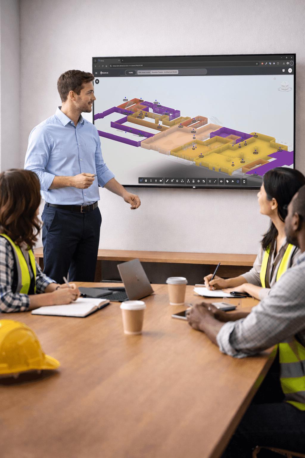 Project team reviewing a colour-coded BIM model on a meeting room screen, each role seeing its own view