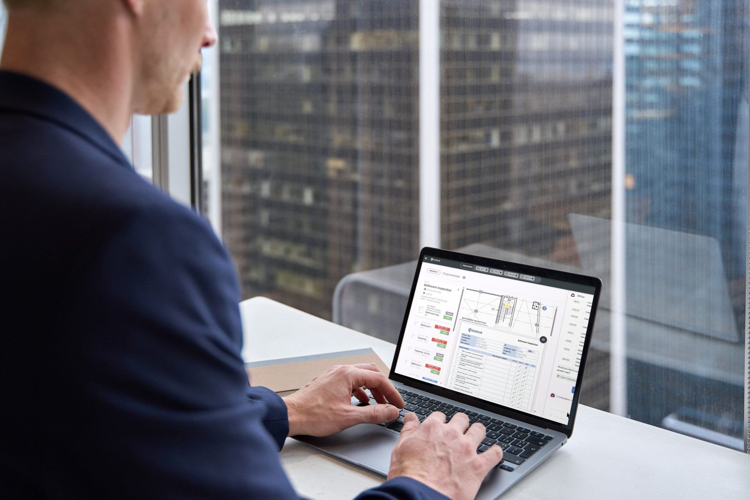 RDrive quality dashboards open on a laptop in an office overlooking the city
