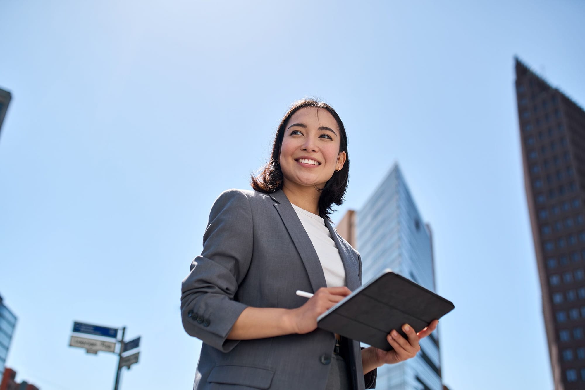 Training administrator with a tablet outside a city office, managing organisation-wide RDrive Academy access